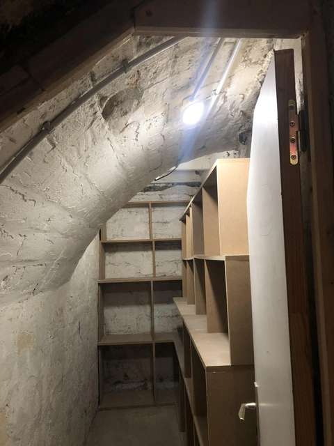 Cave/box/stockage/garage éclairé et aménagé avec étagères de rangement